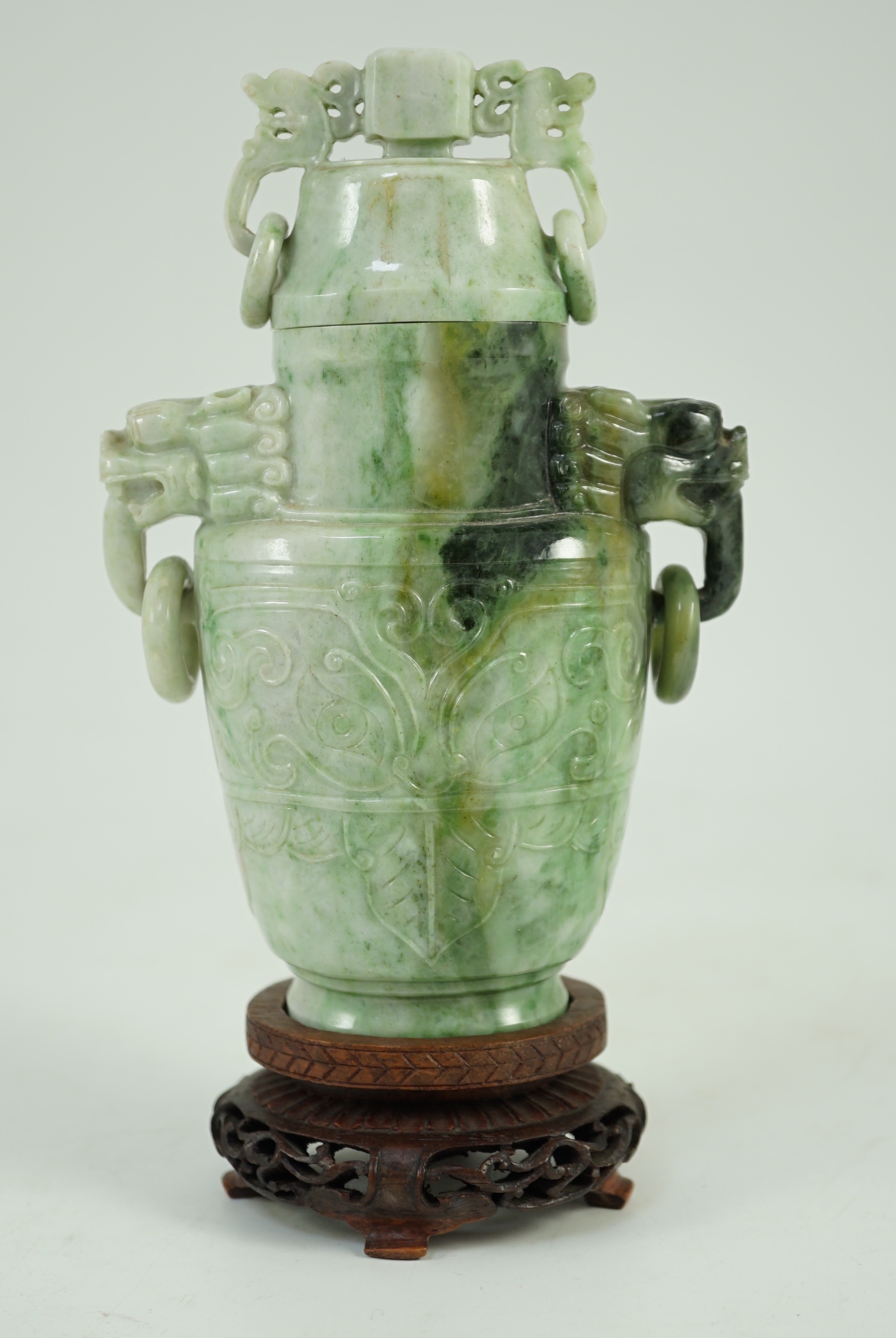 A Chinese archaistic jadeite two-handled vase and cover, first half 20th century, 16 cm high, excluding wood stand